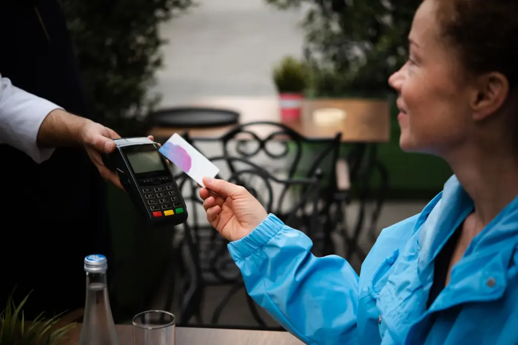 Young-woman-paying-for-her-coffee-with-contactless-credit-card-payment_-MixMedia